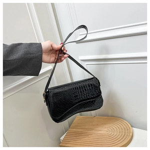 Detailed view of black crocodile pattern faux leather texture with golden metal hardware