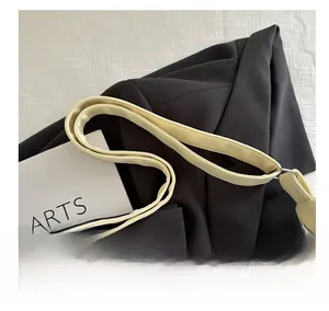 Detail view of wide adjustable cream shoulder strap with silver buckle on a tote bag