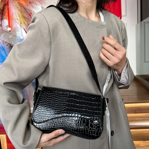 Chic black crocodile pattern leather crossbody bag shown on model with shoulder strap