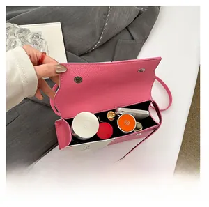 Detail view of pink and white crossbody bag showing interior capacity for phone and cosmetics