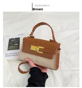 Détail d'un sac à main trapèze en cuir marron et toile beige avec fermoir rotatif doré