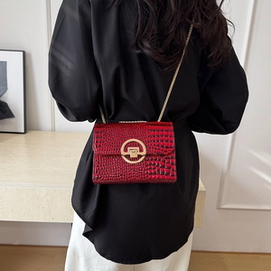 Deep red crocodile texture shoulder bag with large gold buckle and gold chain strap