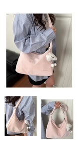 Detail of pink crescent shoulder bag with silver logo and plush cloud charm accessory