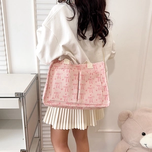 Pink corduroy tote bag with bow pattern and dual front pockets for daily commute