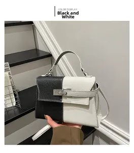 Detail of contrast trapezoid handbag featuring litchi leather and silver turn-lock buckle