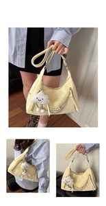 Details der hellgelben Schultertasche mit flauschigem Wolkenanhänger und Perlenkette