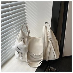 Detalle de bolso medialuna blanco con cadena de perlas y colgante de nube