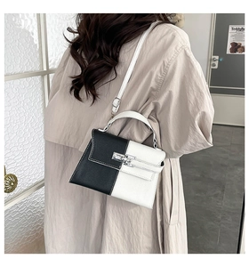 Detail of color-block crossbody bag with silver buckle and adjustable strap on a beige trench coat