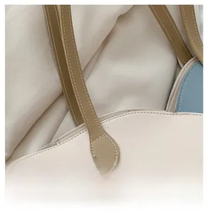 Detail of stitching and bi-color faux leather texture on the commute tote bag