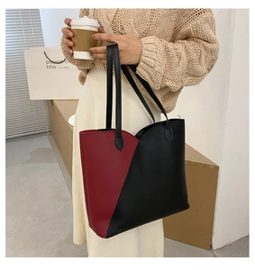Detail of red and black color-block tote bag on model for daily commuting style
