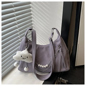 Detalle de bolso lila con cadena de perlas y colgante de nube de felpa blanca suave