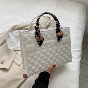 Vue détaillée du sac cabas matelassé blanc avec foulard en soie et broderie lettrée