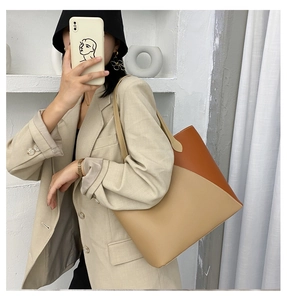 Detail of minimalist tote bag showing color-block beige and caramel leather stitching