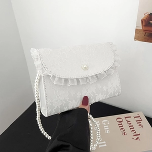Close-up of floral lace crossbody bag featuring pearl clasp and elegant ruffle details