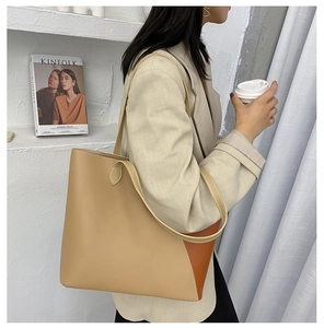 Detailed view of large bi-color tote bag in khaki and dark brown with slim shoulder straps