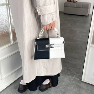 Minimalist black and white contrast leather shoulder bag with metallic clasp detail