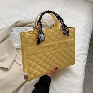 Détail d'un sac cabas jaune matelassé avec broderie Forener Love et foulard en soie