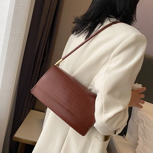 Brown crocodile pattern rectangular baguette bag with a minimalist shoulder strap and gold hardware