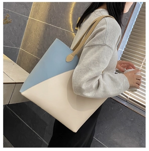 Detail of blue and beige patchwork tote bag with brown leather shoulder straps