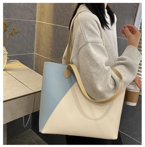 Detail view of the large capacity color-block tote bag on a model shoulder