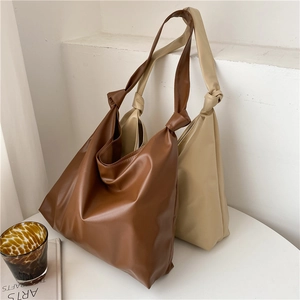 Detail of minimalist tote bags in dark brown and milk tea with chic knotted handles