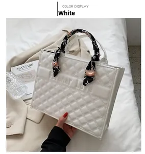 Détail du cabas matelassé blanc avec texte Forever Love et poignée ornée d'un foulard