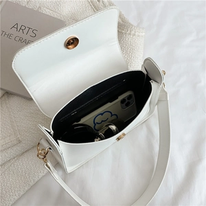 Top view of the white shoulder bag interior with black lining and golden magnetic closure