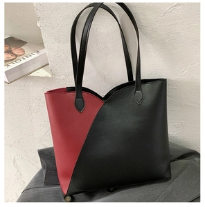 Detail of red and black geometric tote bag with slim handles in a modern minimalist setting