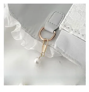 Macro detail of the sweet lace crossbody bag with pearl chain and rose gold D-ring hardware