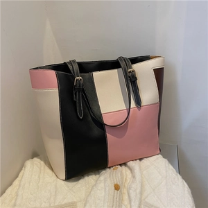 Détail du sac cabas bicolore rose et noir posé sur un tissu en maille douce