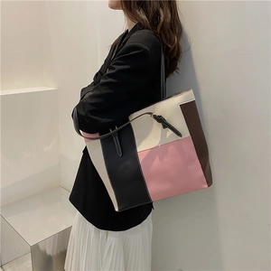 Grand sac cabas bicolore en similicuir porté par un mannequin pour un style chic