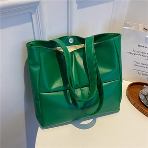Detail view of emerald green puffer tote bag with quilted PU leather and magnetic closure