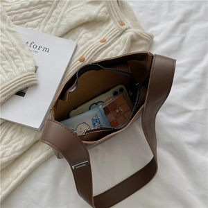 Brown PU leather baguette bag showing spacious interior with phone and makeup essentials