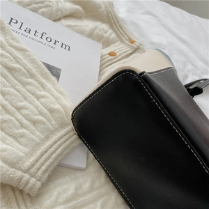 Détail du sac en cuir PU bicolore avec surpiqûres décoratives blanches élégantes
