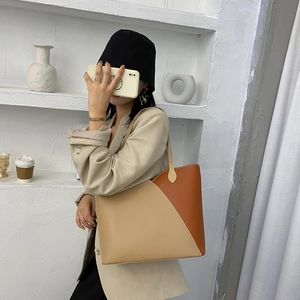 Minimalist large leather tote bag with two-tone beige and caramel brown patchwork design