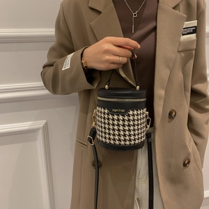 Mini cylindrical houndstooth bucket bag with leather trim and adjustable crossbody strap