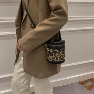 Leopard print cylinder bucket bag with black leather panels and gold hardware