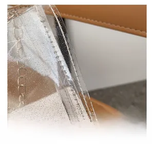 Macro detail of parallel stitching on transparent PVC glitter bag with gold chain strap