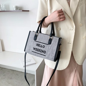 Chic canvas tote bag with HELLO WEEKEND text and leather handles shown on model