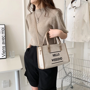 Canvas tote bag with Hello Weekend print and brown leather trim shown on a model