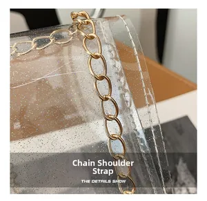 Detail of gold metal chain strap attached to transparent PVC jelly bag with glitter