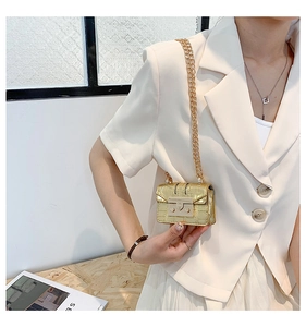 Détail du mini sac doré effet crocodile avec bandoulière chaîne et fermoir rabat
