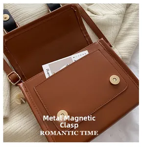 Détail du sac en similicuir marron avec deux fermoirs magnétiques en métal doré brillant