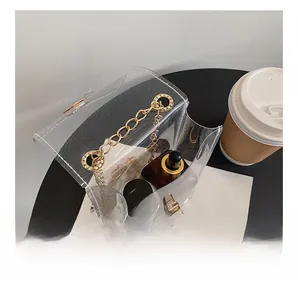 Detail view of transparent PVC mini crossbody bag with gold metal chain and turn-lock