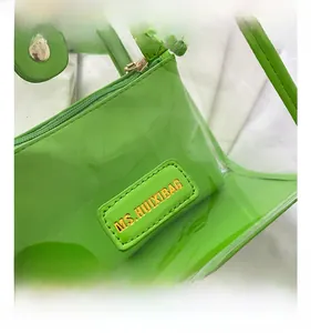 Detailed close-up of bright green transparent PVC tote and internal zipper pouch logo