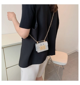 Détail du mini sac bandoulière argenté à motif pierre avec chaîne dorée sur mannequin
