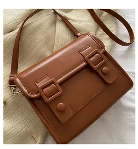 Détail d'un sac bandoulière en similicuir marron avec sangle réglable et crochets