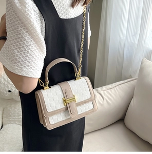 Close-up of woven flap shoulder bag with gold H-clasp and metallic chain strap