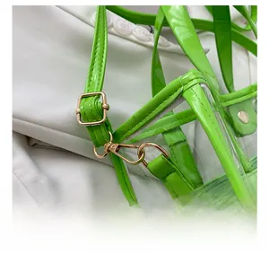 Detail of neon green PVC tote bag showing gold metal hook and leather strap stitching