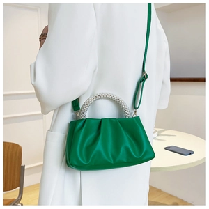 Détails du sac plissé vert avec une poignée élégante en perles et une bandoulière fine